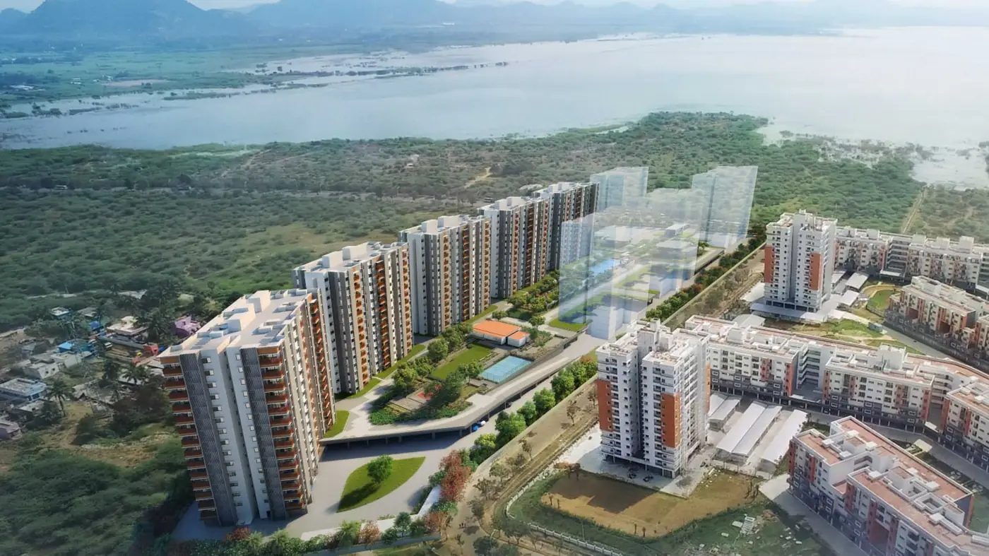 Aerial view of Mahindra World City showing completed residential towers beside the new Lakewoods towers, with Kolavai lake behind them.